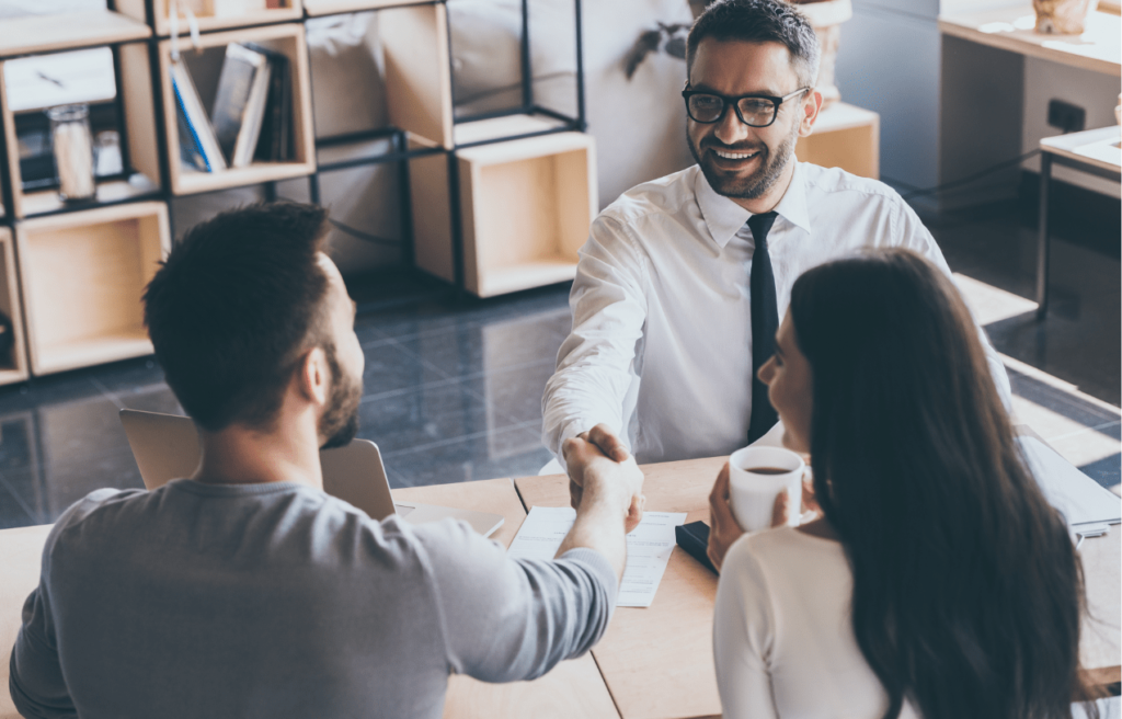 three people have a meeting over coffee