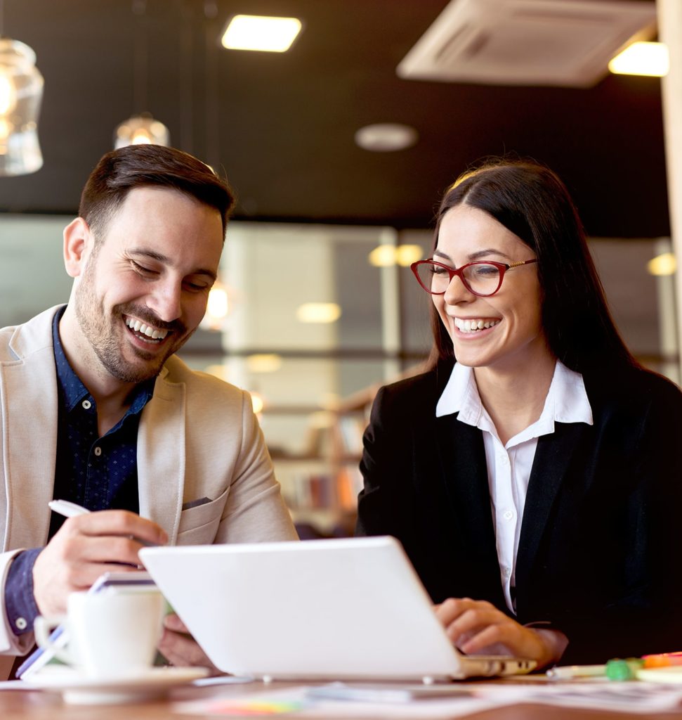 woman and man looking at computer together smiling